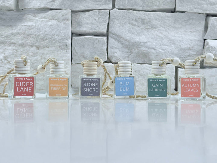 Set of small bottles with labels on a reflective surface and stone wall background