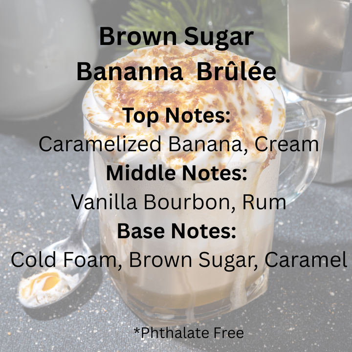 A glass mug filled with a whipped cream and caramel-topped beverage sits on a countertop with overlaid scent notes reading 'Brown Sugar Bananna Brûlée' and fragrance notes. The background is softly blurred, with a spoon and metallic object visible.