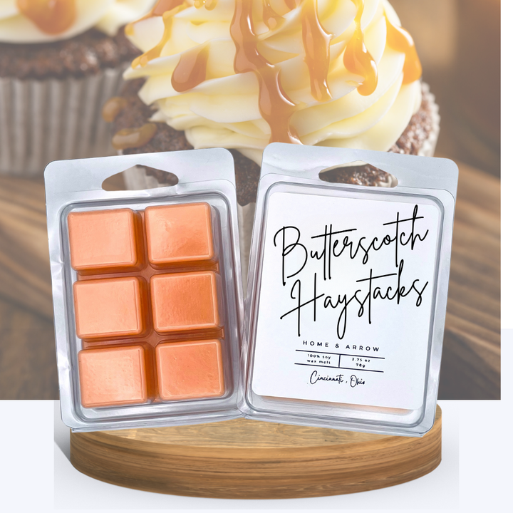 Butterscotch Haystacks wax melts in clamshell packaging, displayed on a wooden stand with a butterscotch topped cupcake in the background.