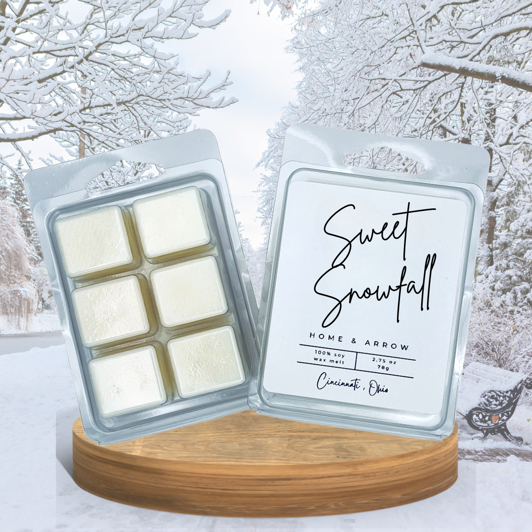 Wax melts in packaging with 'Sweet Snowfall' label against a snowy background